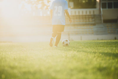 Man playing soccer ball on grass