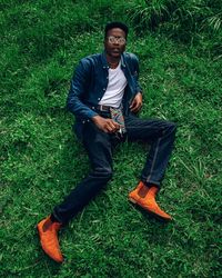 Portrait of young man sitting on field