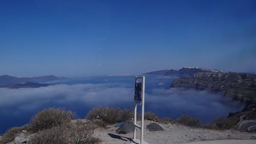 Smoke emitting from mountain against blue sky