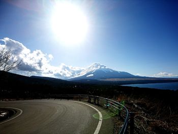 Scenic view of road by mountains against sky