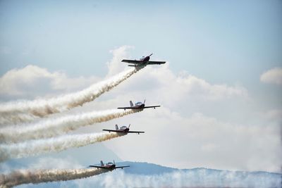 Low angle view of airshow against sky