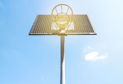 Directly below shot of basketball hoop against blue sky