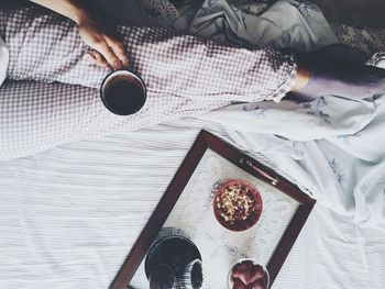 Low section of woman having breakfast on bed
