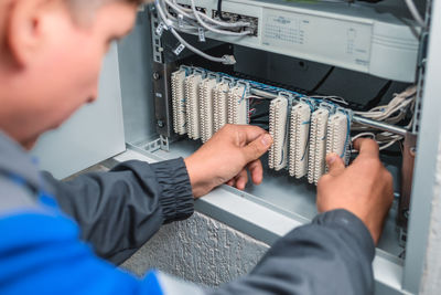 Midsection of electrician checking electrical equipment