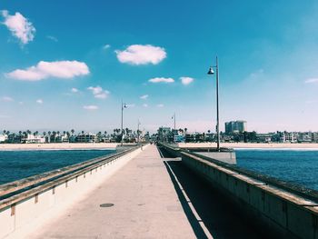 Street by sea against sky in city