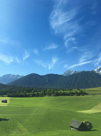 Scenic view of golf course against blue sky