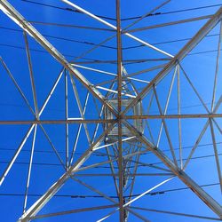 Low angle view of power lines against blue sky