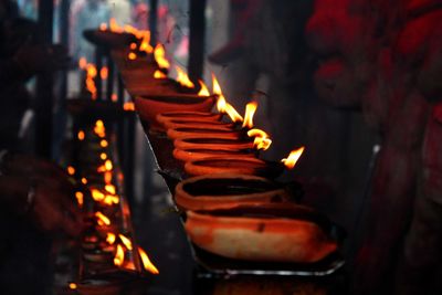 Close-up of diyas burning in temple