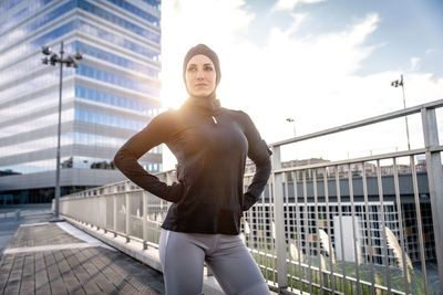 Beautiful woman standing against building in city