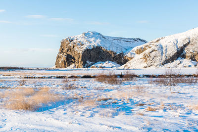 Scenic view of frozen lake by snowcapped mountain against sky