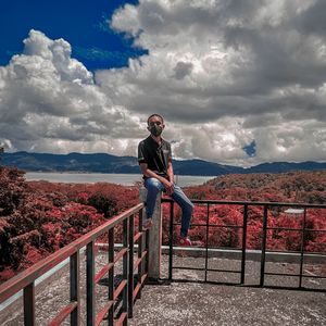 Man on railing against mountains