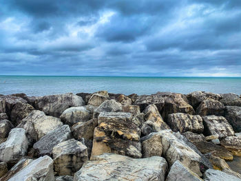 Rocks by sea against sky