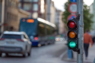 Blurred view of city traffic with traffic lights, in the foreground a semaphore with a green light