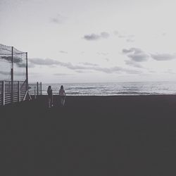 Silhouette people on calm beach