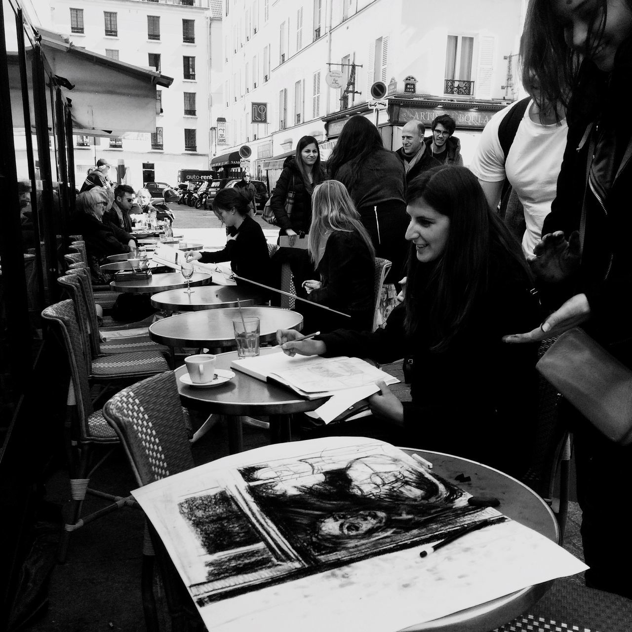 city, men, building exterior, large group of people, person, architecture, city life, built structure, lifestyles, street, leisure activity, sitting, incidental people, medium group of people, sidewalk cafe, chair, high angle view, day, table