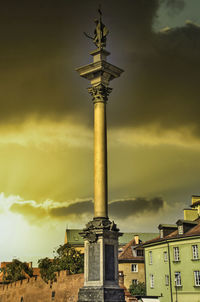 Low angle view of statue in city against cloudy sky