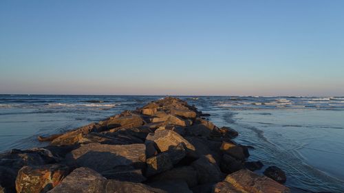 Scenic view of sea against clear sky at sunset