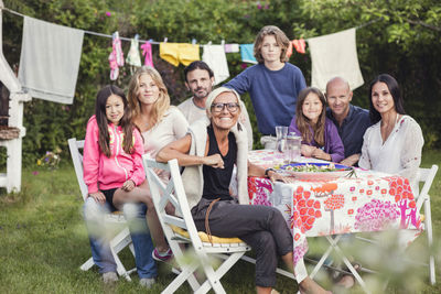 Portrait of happy family and friends in back yard during garden party