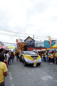 People on street in city against sky