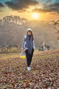 Full length of woman standing on field against sky