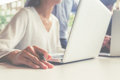 Close-up of woman using laptop on table at home