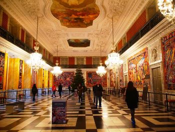 People in illuminated corridor