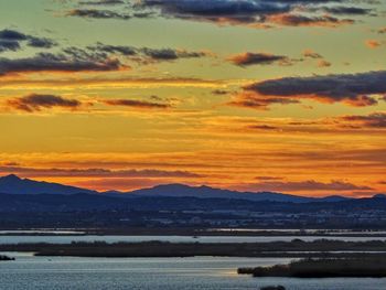 Scenic view of sea against dramatic sky during sunset