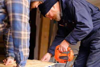 Midsection of man working on wood