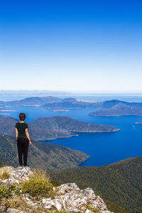 Man standing on mountain against clear blue sky