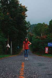 Full length of woman walking on road against sky