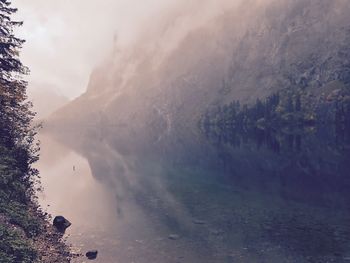 Scenic view of river by mountains against sky
