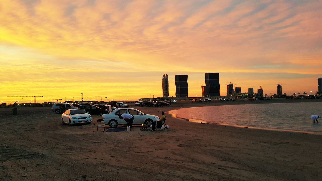 sunset, sky, water, cloud - sky, orange color, shore, scenics, tranquility, nature, cloudy, beauty in nature, cloud, outdoors, tranquil scene, idyllic, city, travel destinations, dramatic sky, no people, tourism