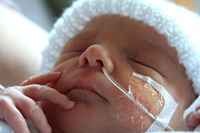 Newborn hospital shot with hand to face. 