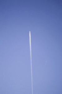 Low angle view of airplane emitting vapor trail against clear sky