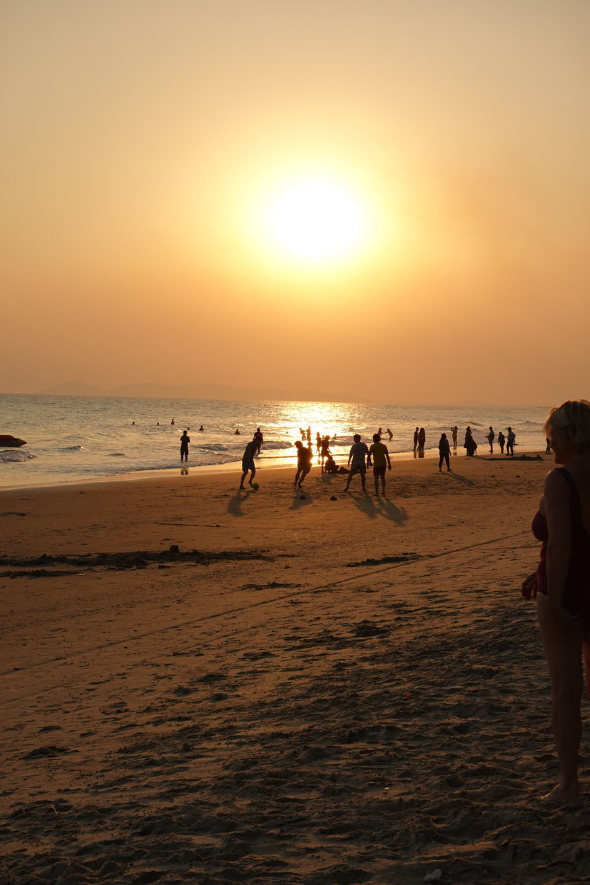 SILHOUETTE PEOPLE ON BEACH AGAINST SUNSET SKY