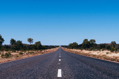 Road against clear blue sky