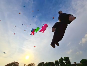 Low angle view of people flying against sky