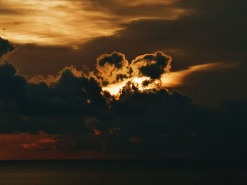 Scenic view of sea against dramatic sky during sunset