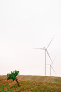 Windmill on field against clear sky