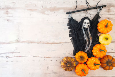 High angle view of skull and pumpkins on table during halloween