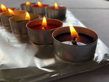 Close-up of lit tea light candles in temple