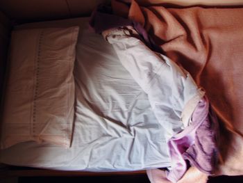 Low section of man relaxing on bed at home