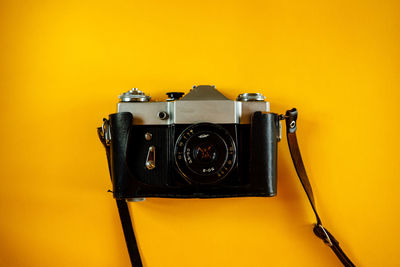 Close-up of vintage camera against wall