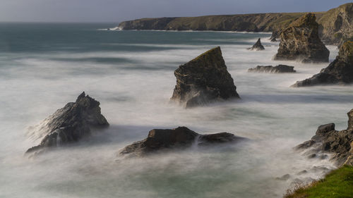 Scenic view of rocks in sea against sky