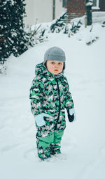 Boy wearing hat standing in snow