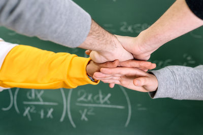 Cropped image of people stacking hands
