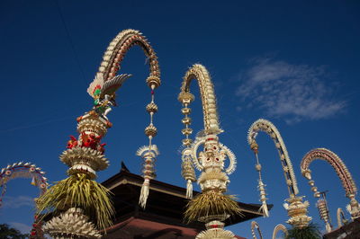 Low angle view of sculpture and building against sky