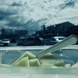 Close-up of food in city against sky