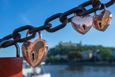 Close-up of padlocks on chain against sky