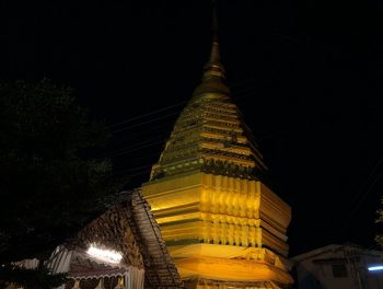 Low angle view of illuminated building against sky at night